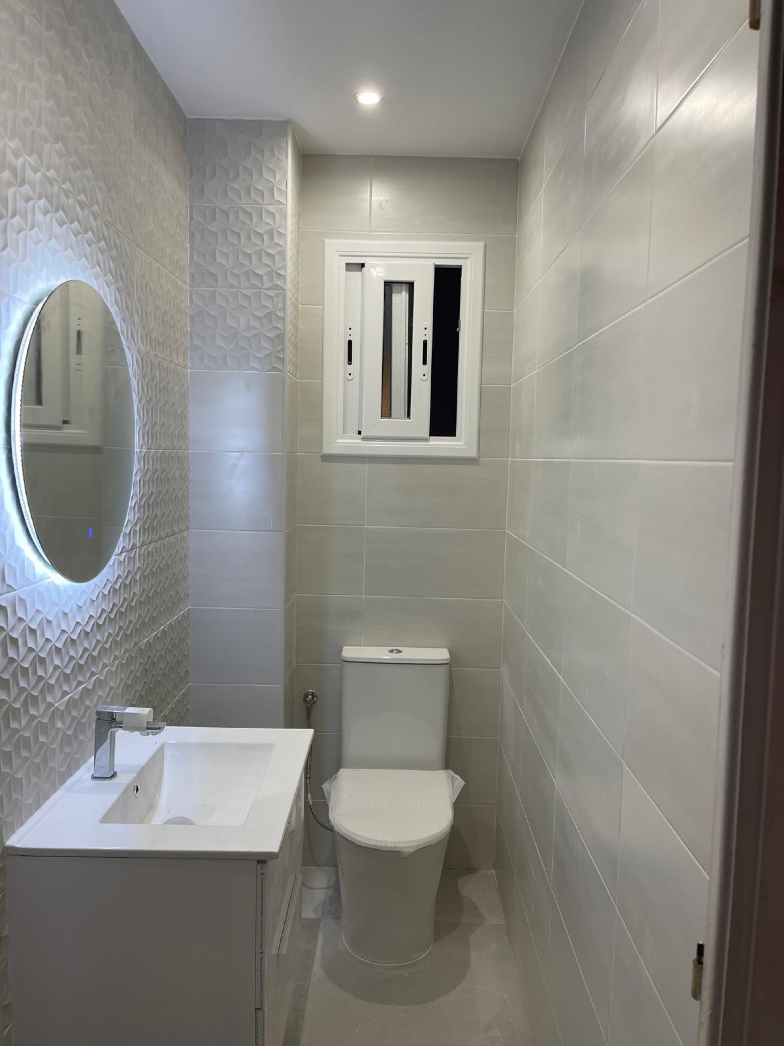 Baños · Baño con pared texturizada y espejo — Reformas Gran Decor Barcelona
